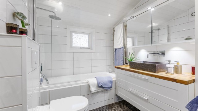 Helflist bad i 2. etasje med badekar og dusjløsning.