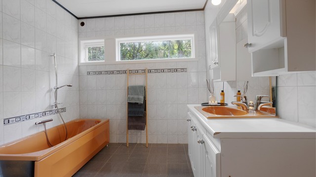 Vegghengt servantinnredning og badekar med vegghengt armatur.