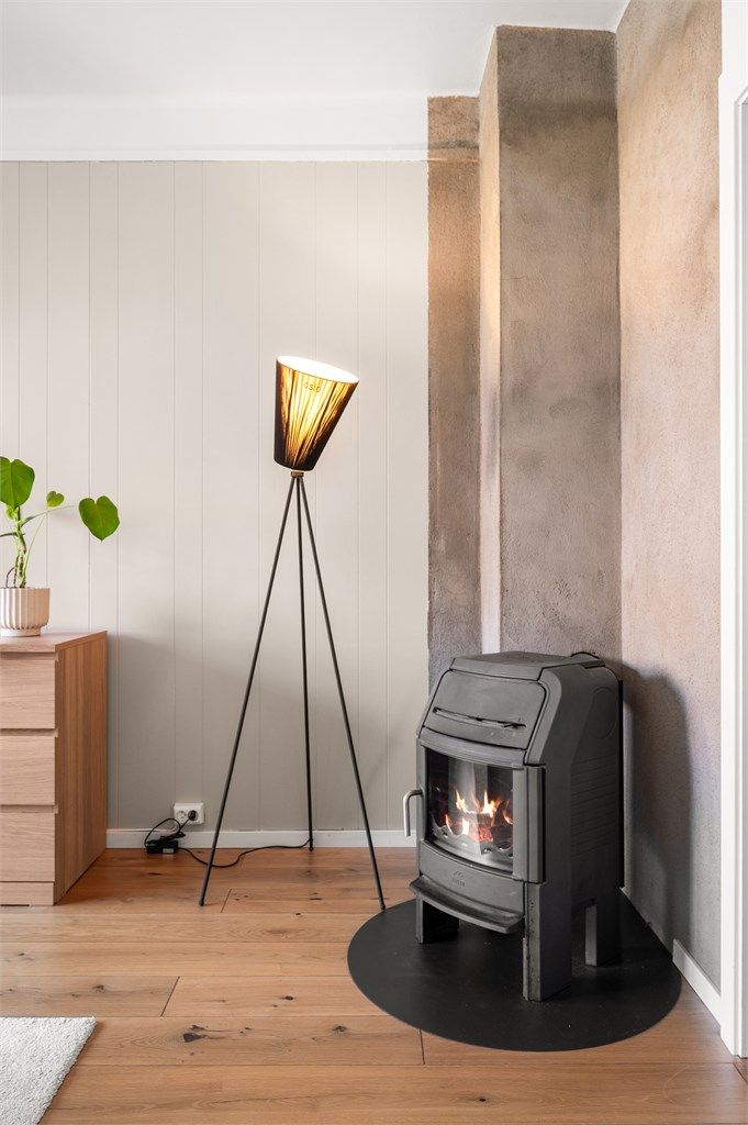 Stuen har en sjenerøs takhøyde på 2,68 meter og en vedovn for ekstra varme. Den lekre enstavs eikeparketten er gjennomgående i boligen.