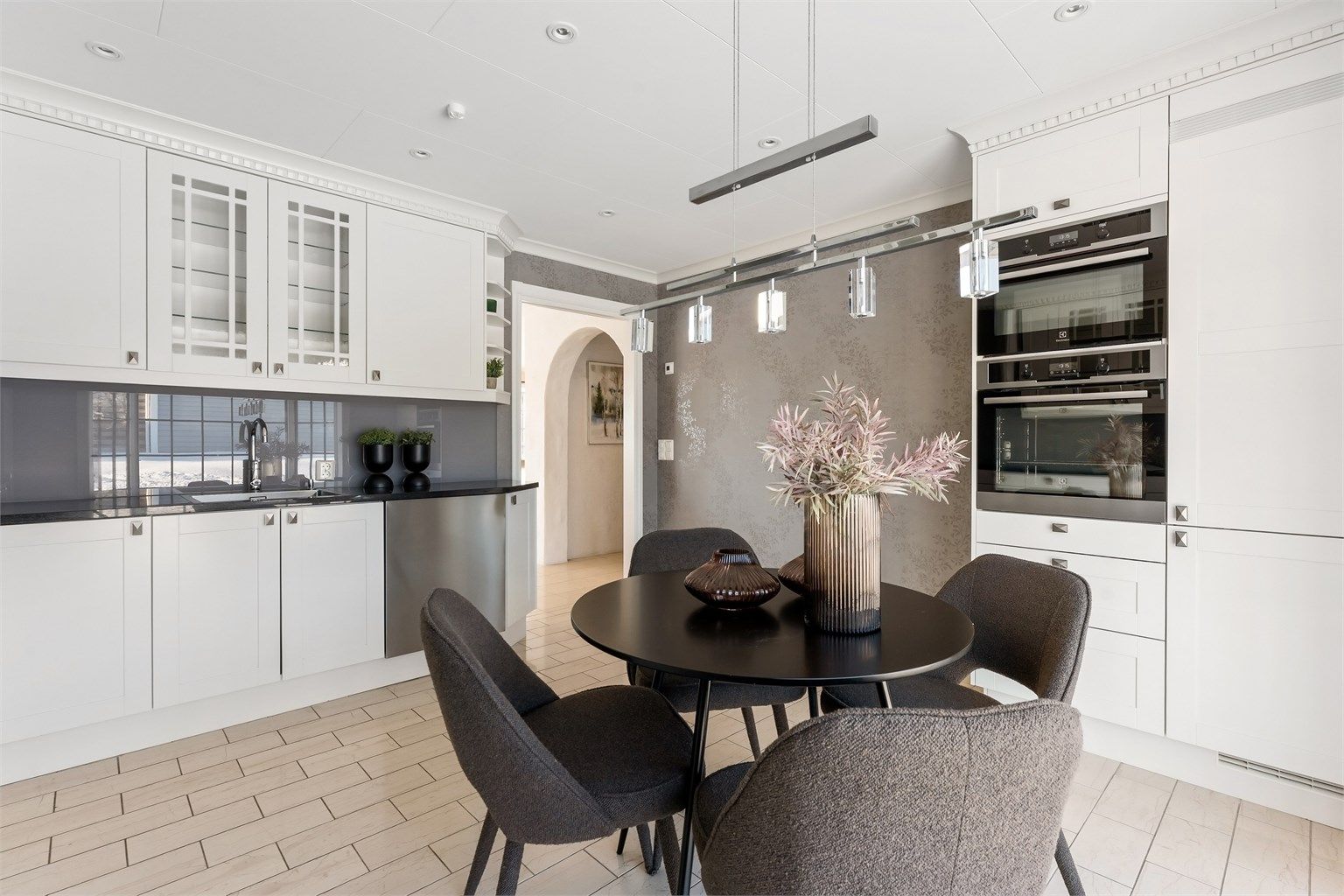 Innredningen har profilerte fronter og integrerte hvitevarer som stekeovner, kjøleskap og fryser.