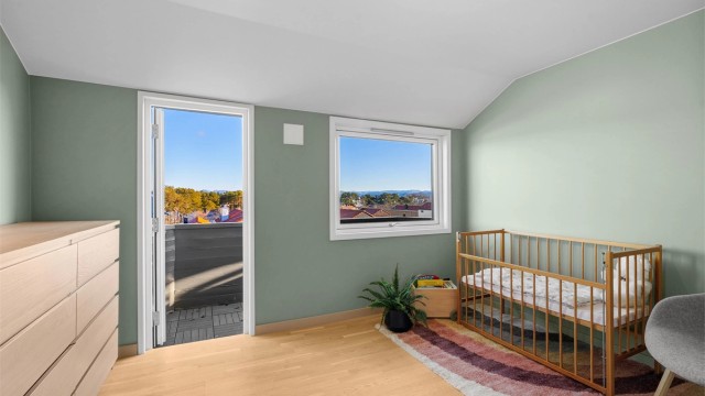 Soverom I med god plass til stor seng, nattbord og kommode om ønskelig. Her er det parkett på gulv, vegger malt i en fin farge og utgang til østvendt balkong. Flott utsikt fra rommet og balkong.