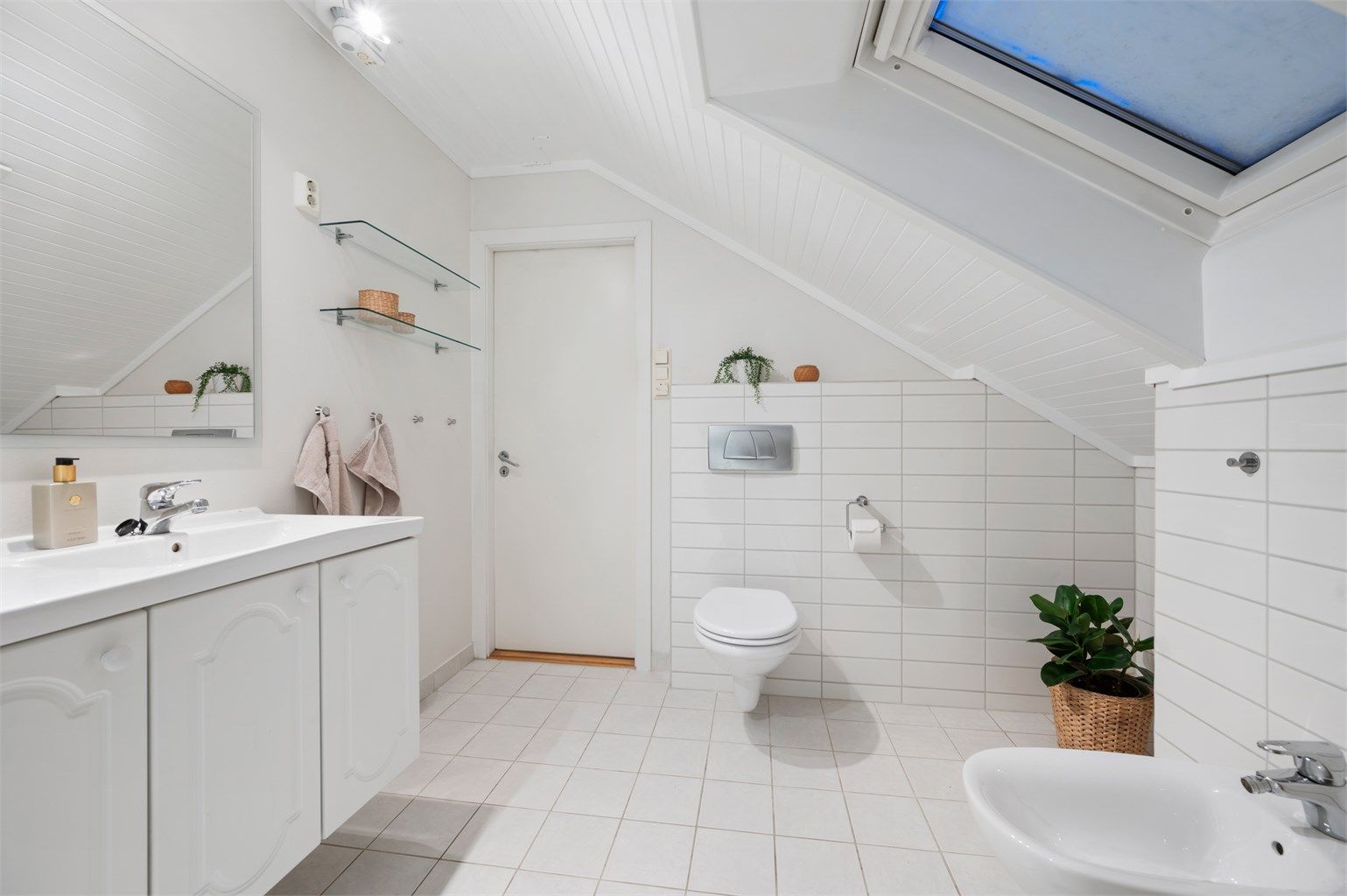 Badet er videre utstyrt med servantskap med speil, dusjhjørne, bidé og vegghengt toalett.