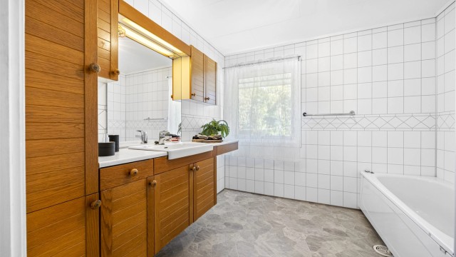 Baderomsinnredning med vegghengt servantskap og speil med overlys.