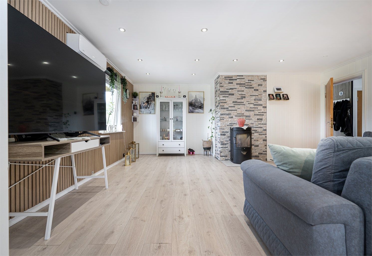 Stuen har god plass til sofagruppe og er utstyrt med et ildsted fra byggeåret.