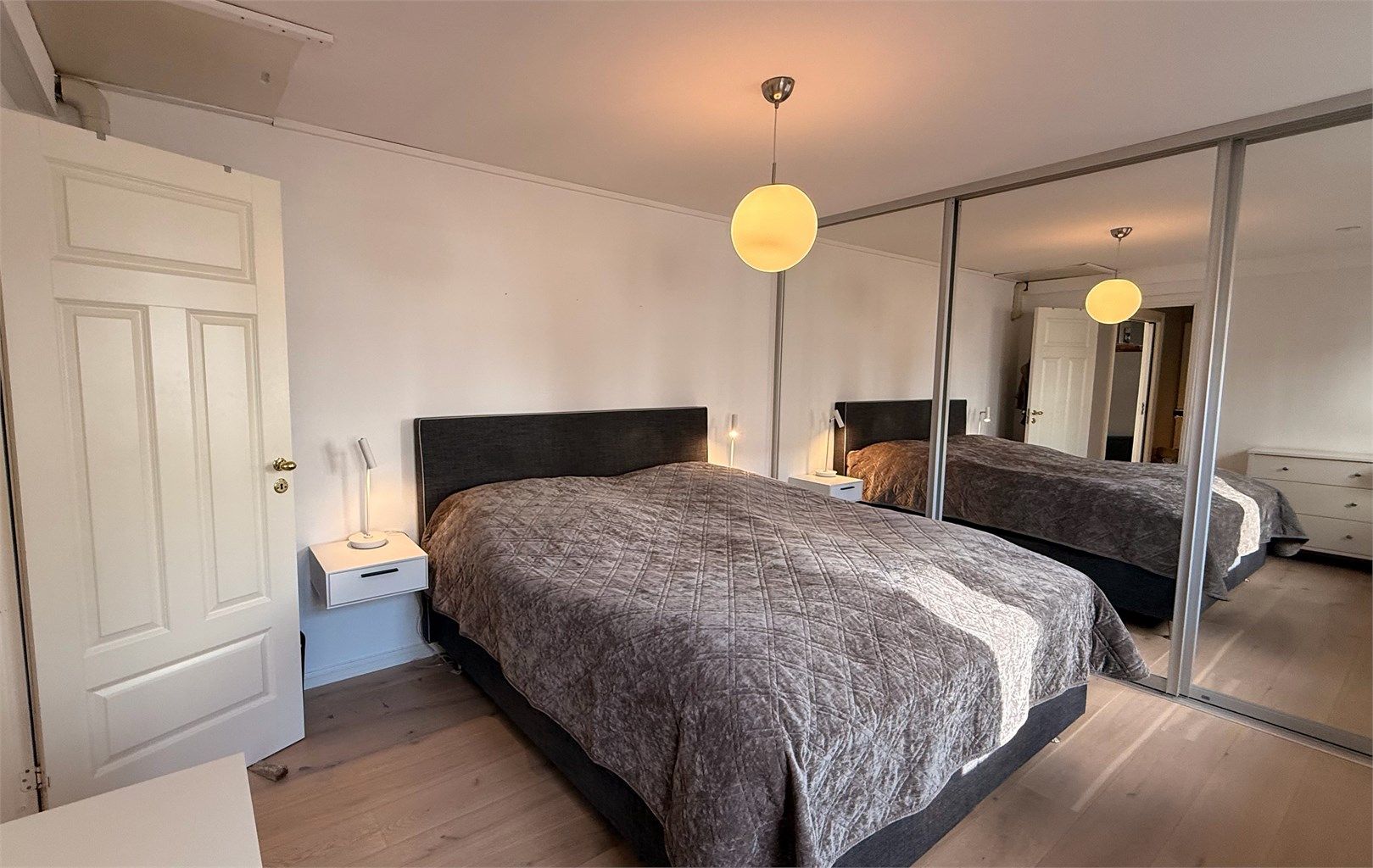 En stor skyvedørsgarderobe med speilfronter gir rikelig med oppbevaringsplass