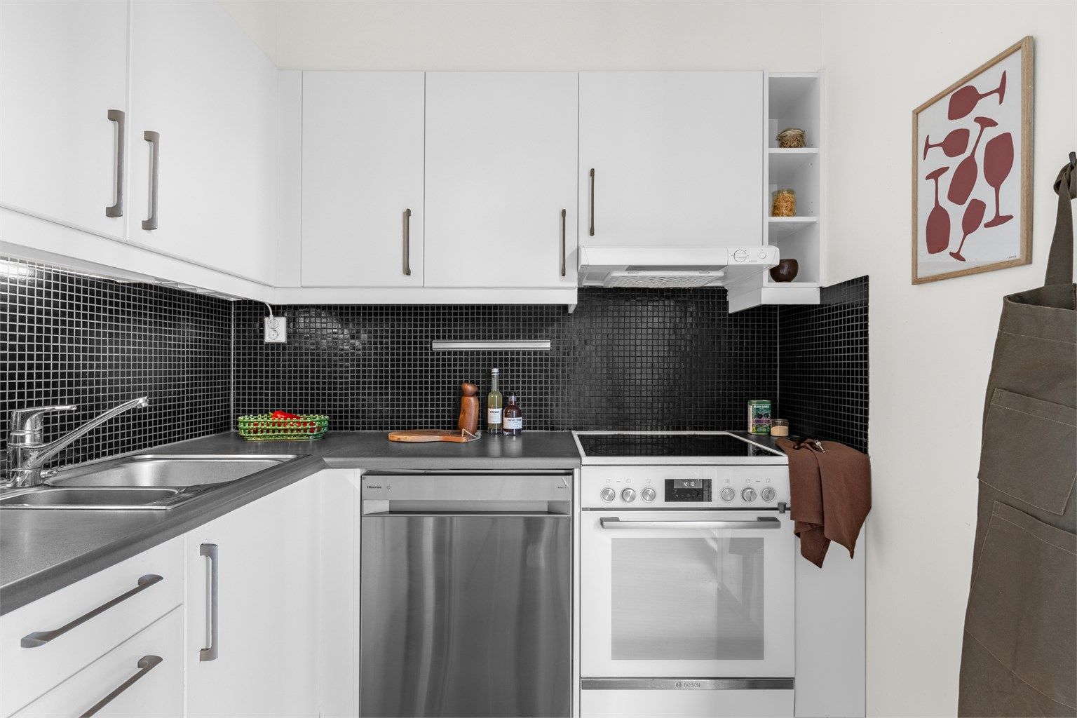 Kjøkkeninnredningen består av glatte laminerte/lakkerte fronter, laminert benkeplate med oppvaskkum og et-greps blandebatteri fra Oras.