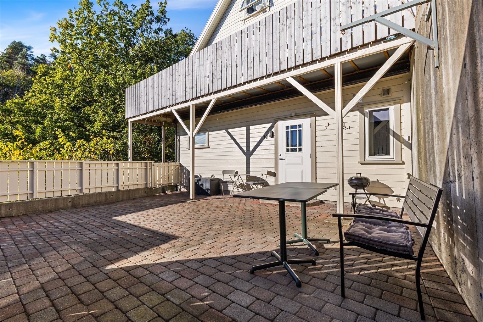 Uteplassen er lagt med belegningsstein og har god plass til sittegruppe og grill.