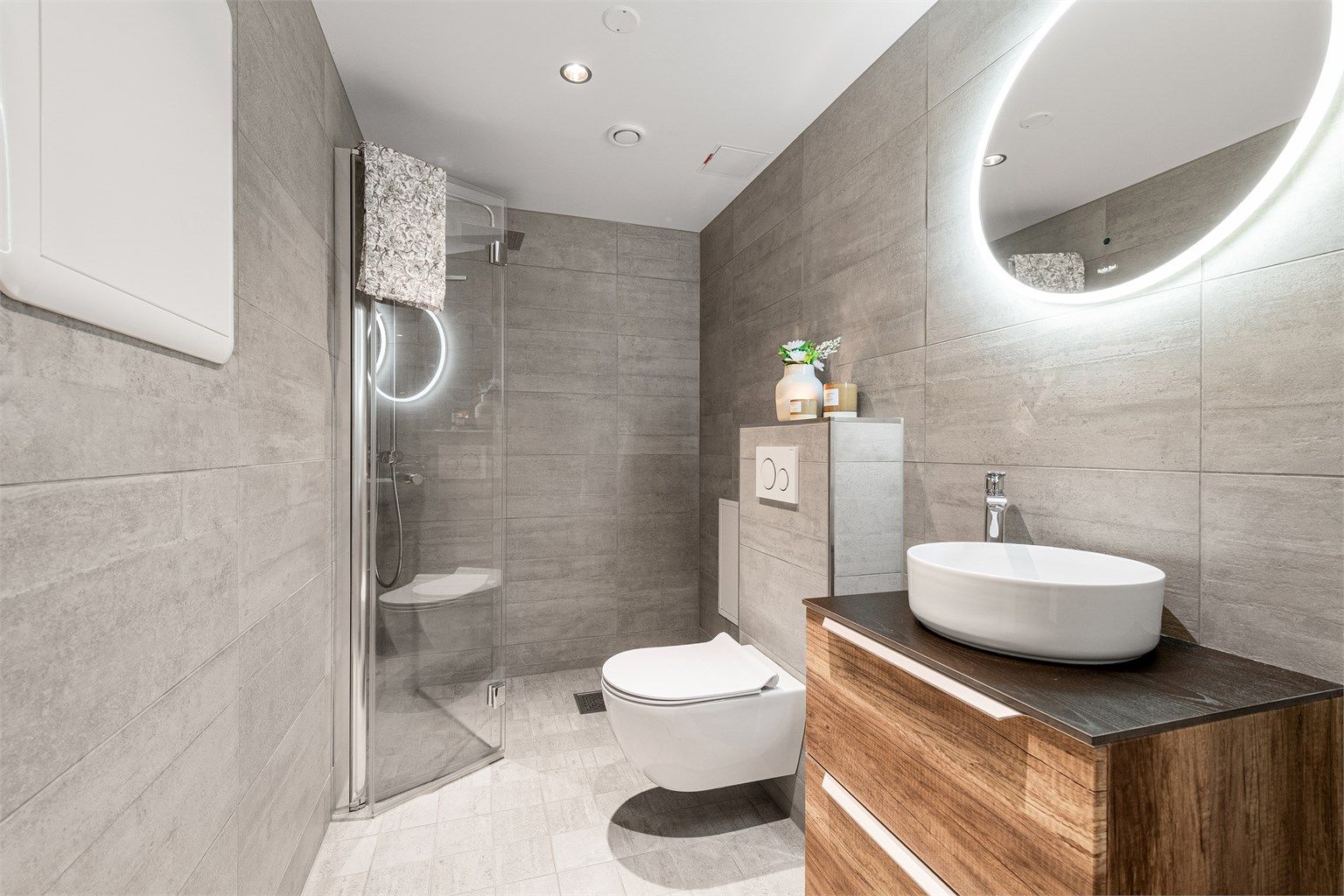 Leilighetens andre bad ble også oppgradert i 2018. Her er det dusjnisje med glassdør og regndusj