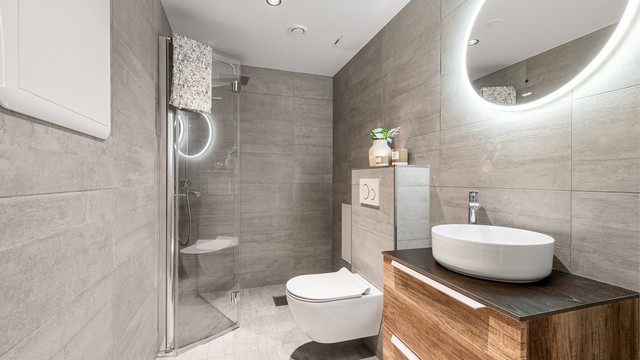 Leilighetens andre bad ble også oppgradert i 2018. Her er det dusjnisje med glassdør og regndusj