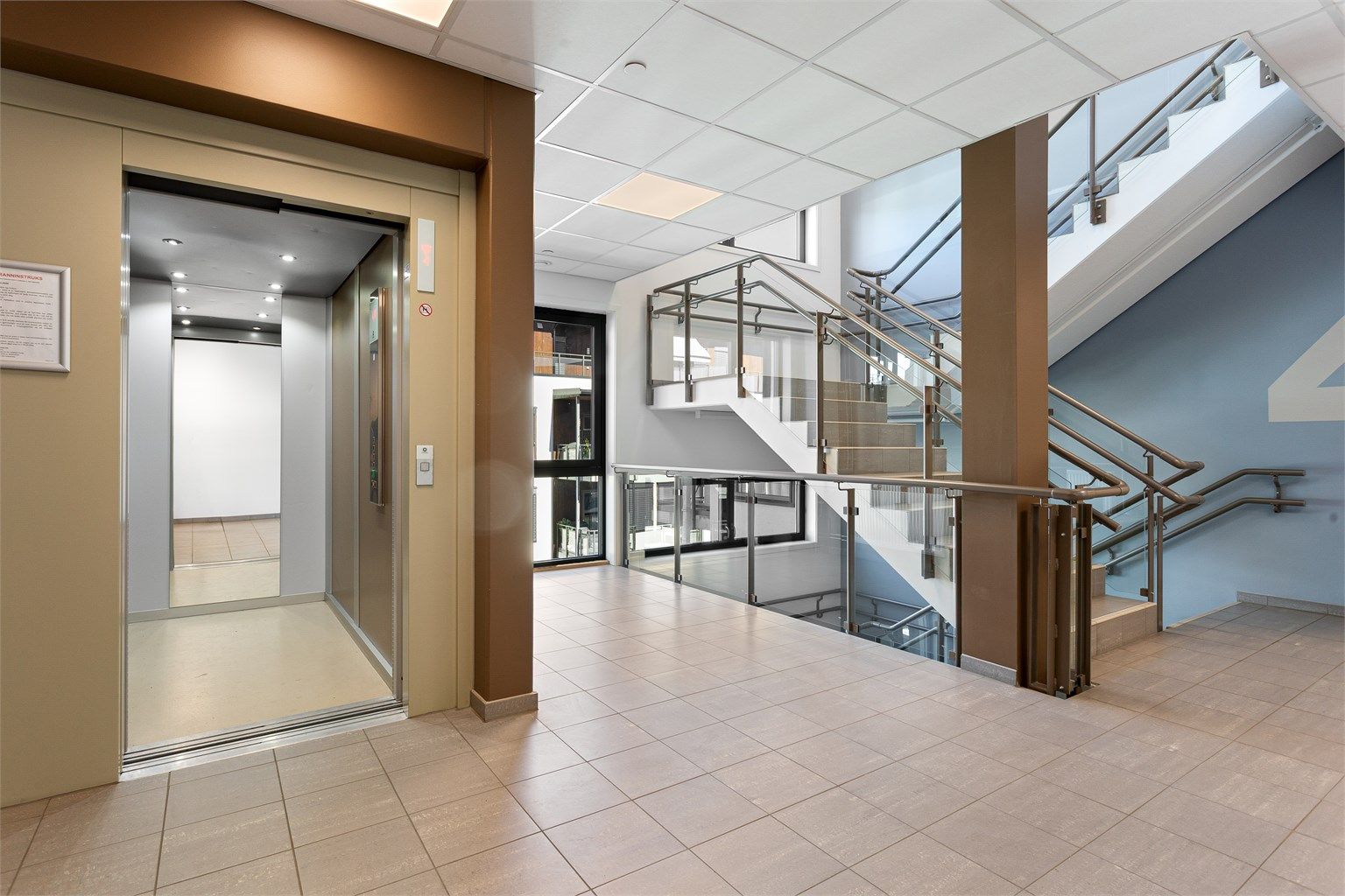 Fellesarealene er lyse og velholdte, med heis som tar deg direkte opp til leilighetens etasjeplan.