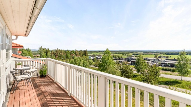 En av to balkonger i andre etasje, begge belagt med terrassebord.
