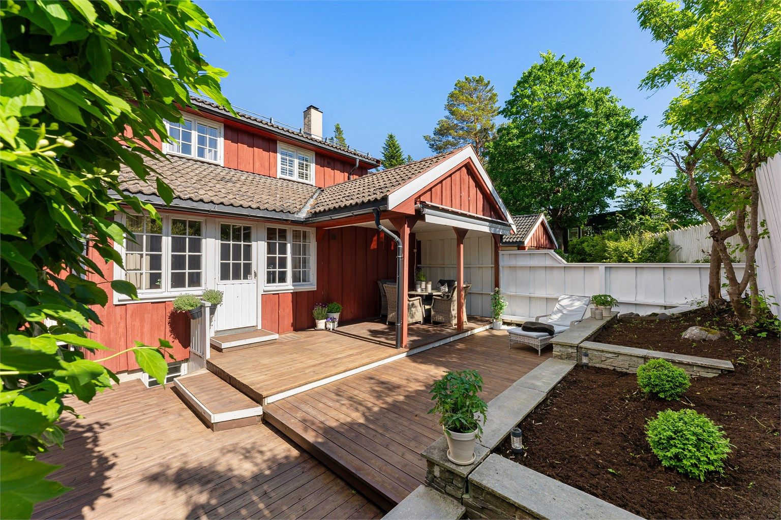 Uteområdet er pent opparbeidet med terrasse i tre og støttemur i naturstein.