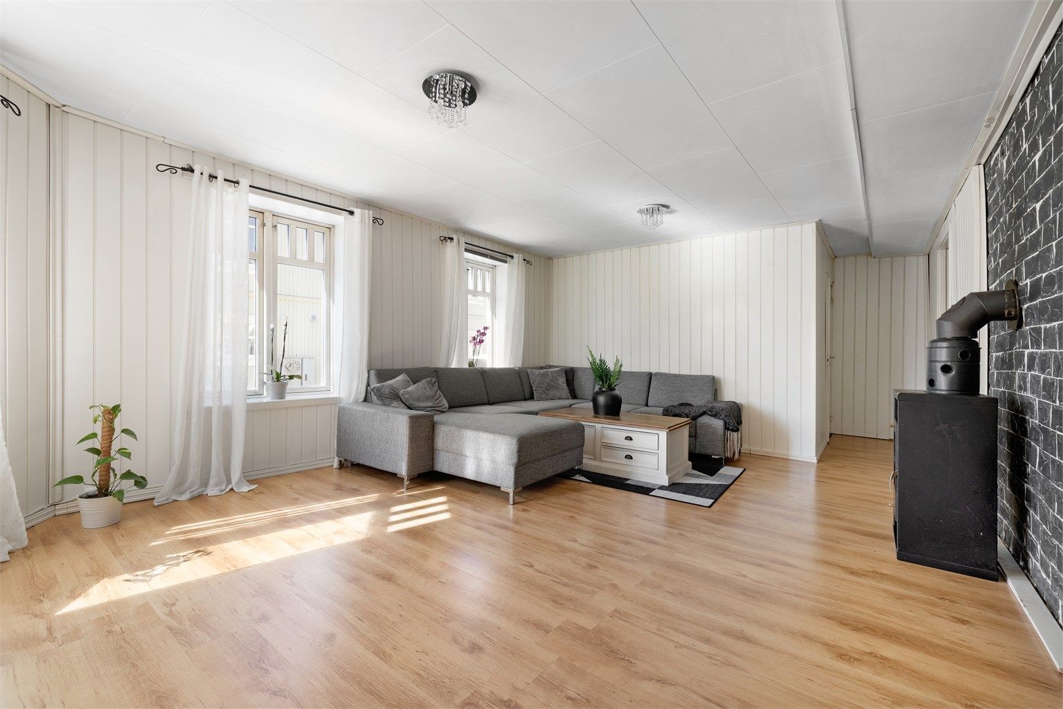 De store sosiale rommene stuen og kjøkkenet utgjør i dag mye av arealet i første etasje. Ett soverom er skilt ut fra stuen.