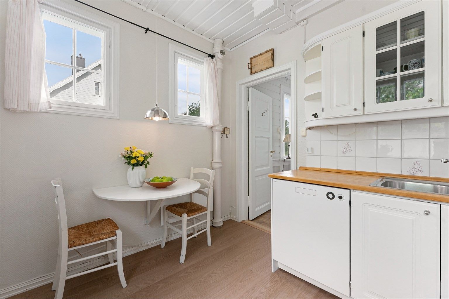 Kjøkkenet har vinyllaminat på gulvet og panel i himlingen.