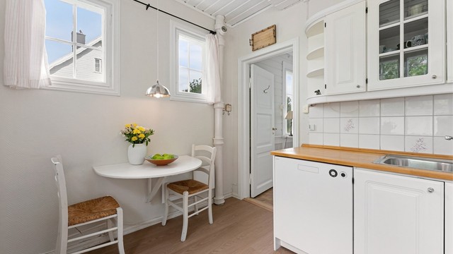 Kjøkkenet har vinyllaminat på gulvet og panel i himlingen.