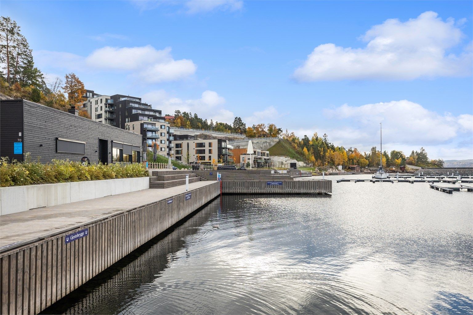 Bred trebrygge og promenade langs vannkanten i Spro Havn.