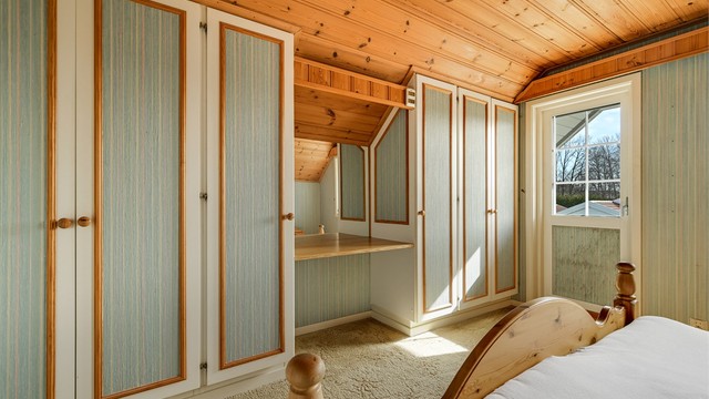 Soverommet er innredet med en praktisk skrivepult integrert i garderobeløsningen.