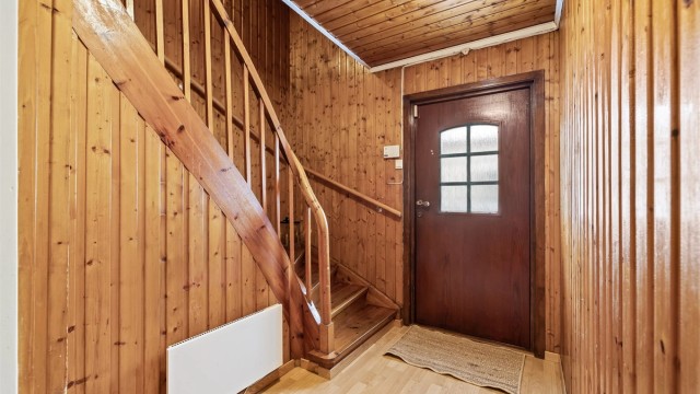 Innvendig trapp i trekonstruksjon binder boligens tre plan sammen.