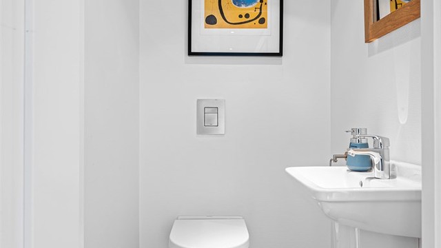 Wc i denne etasjen har parkett på gulv, lyse vegger, enkel servant.
