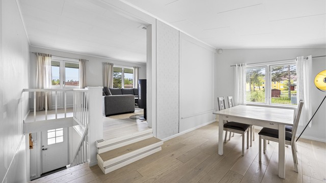 Stuen og spisestuen er plassert i en åpen, men likevel definert sone med gjennomgående parkettgulv.