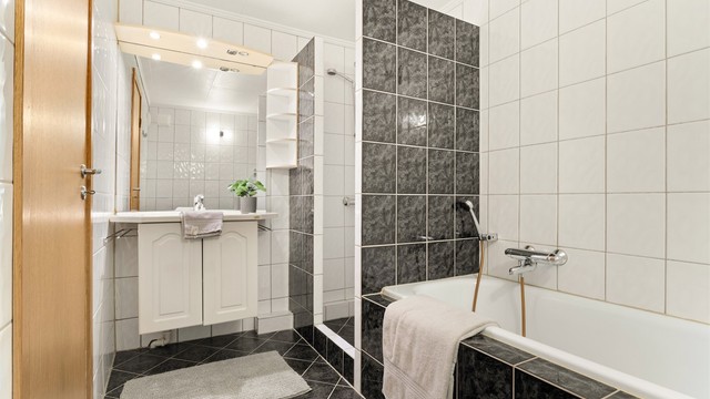 Helfliset bad i underetasjen med både dusj og badekar