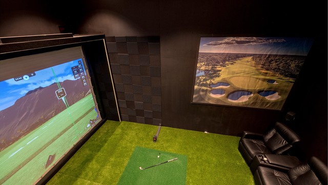 Eget rom tilpasset for golfsimulator med kunstgress og ekstra takhøyde.