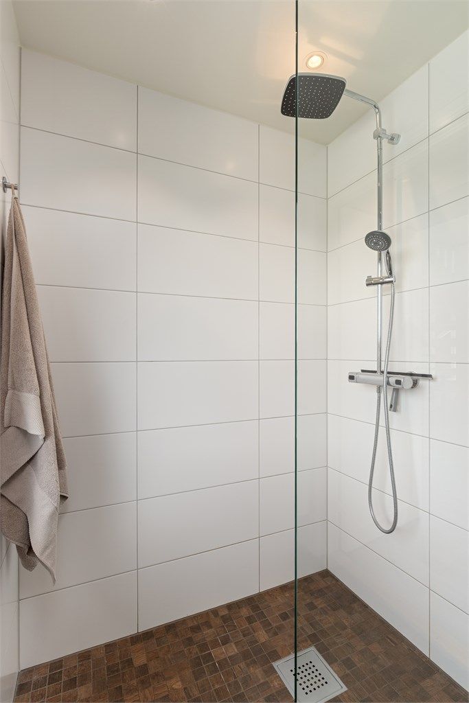 Badet er innredet med gulvstående toalett, servantmøblement og dusjhjørne