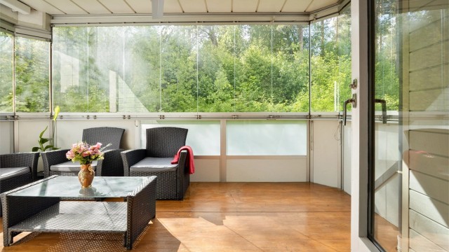 Den romslige, innglassede balkongen fungerer som et ekstra oppholdsrom store deler av året.