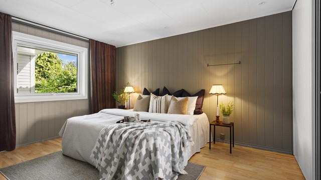 Romslig hovedsoverom med stor vindusflate og skyvedørsgarderobe