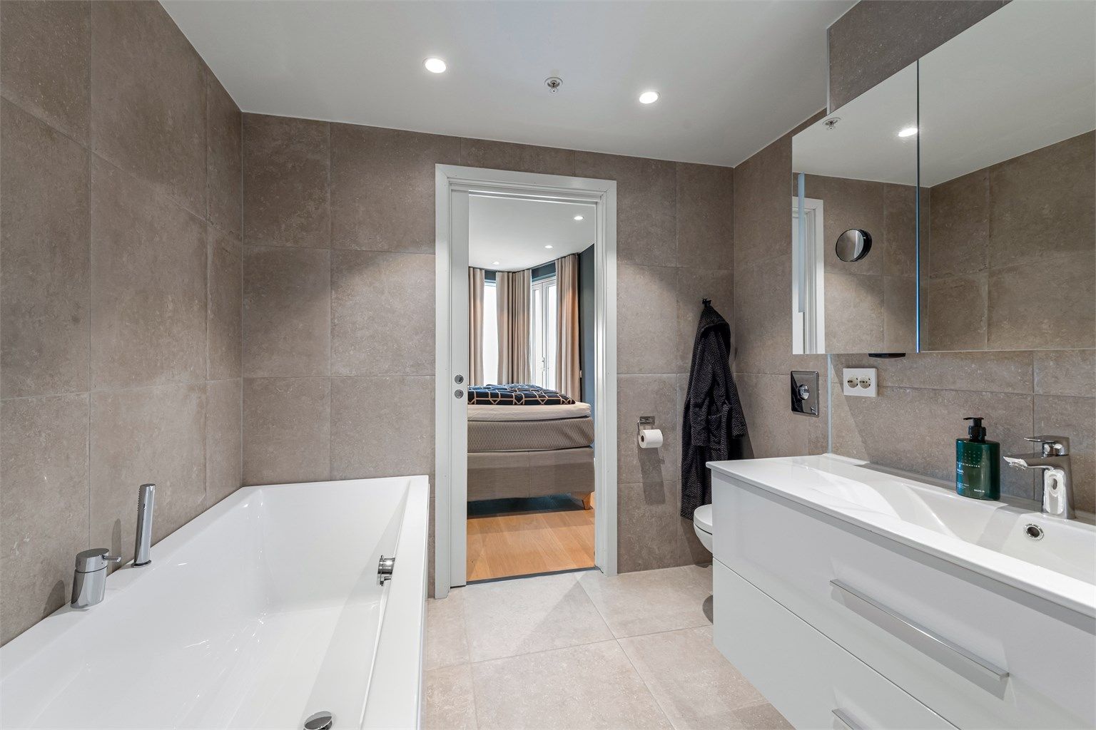 Badet har adkomst via skyvedør fra hovedsoverom