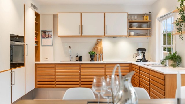 Kjøkkenet har rikelig med skap- og benkeplass og glatte flater. Downlights i himling