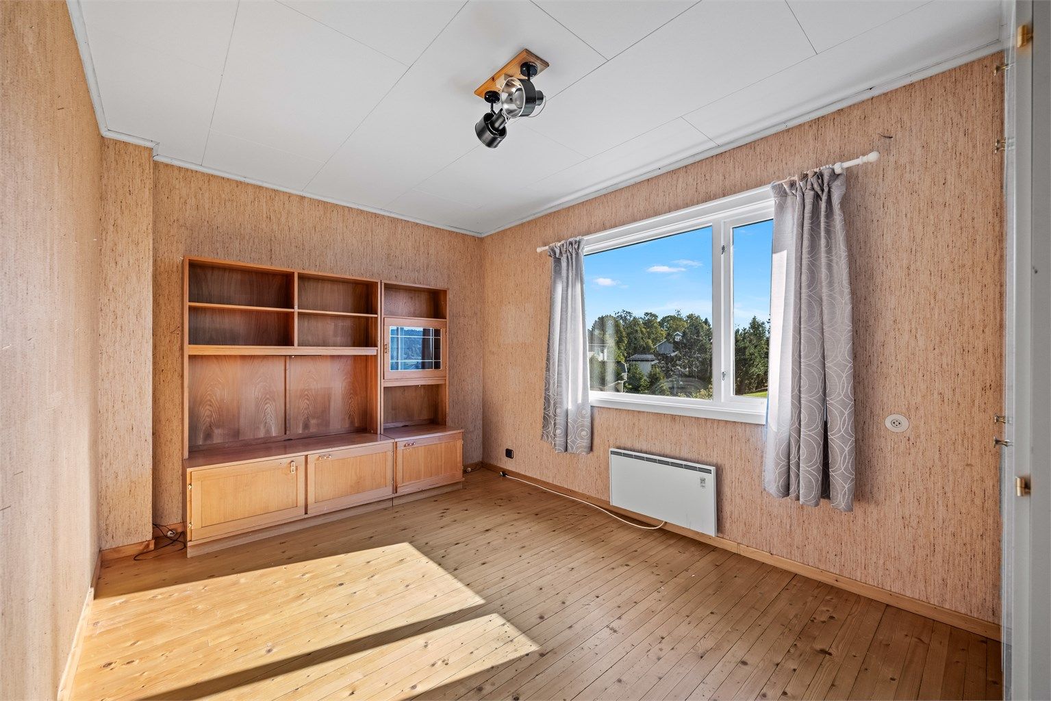 Soverom i andre etasje med tregulv og god plass til seng og skap.