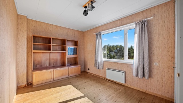 Soverom i andre etasje med tregulv og god plass til seng og skap.