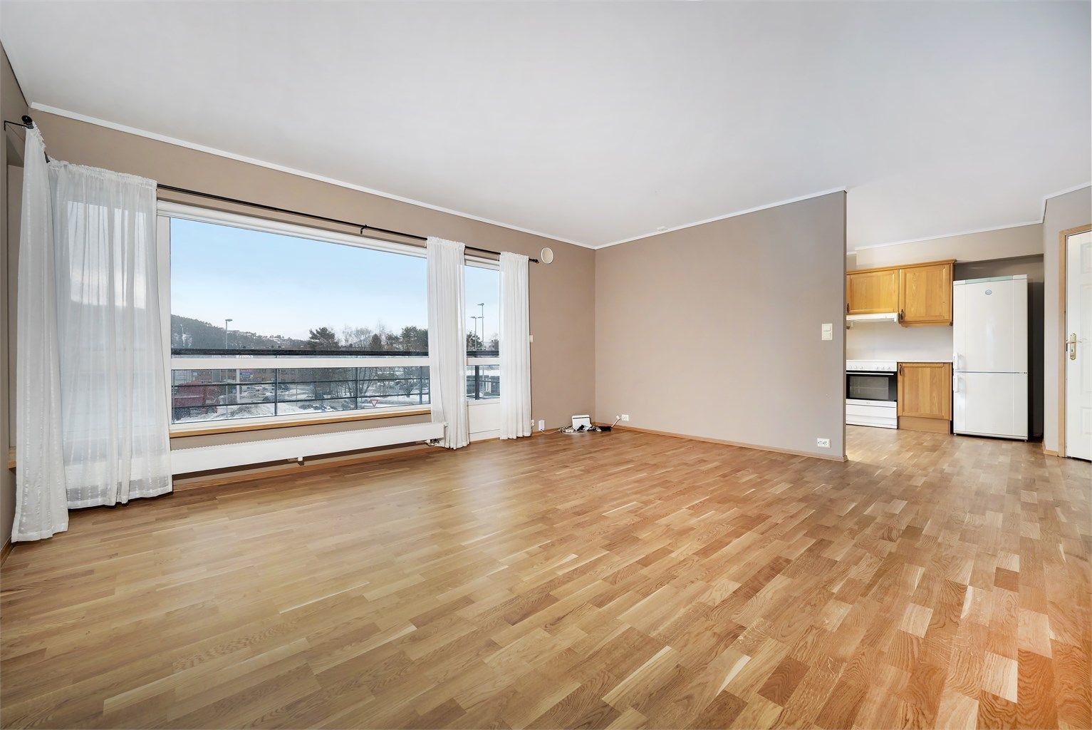 Den delvis åpne løsningen mot kjøkkenet skaper en sosial og luftig atmosfære.