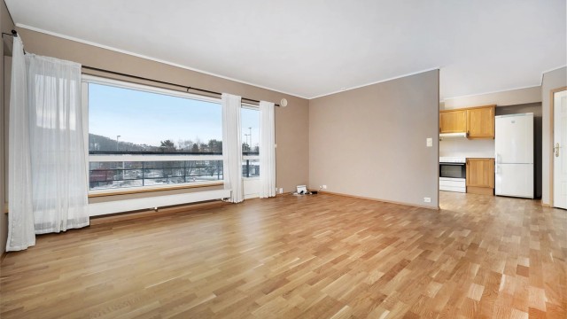 Den delvis åpne løsningen mot kjøkkenet skaper en sosial og luftig atmosfære.