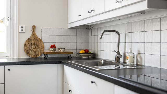 Fliser mellom kjøkkenbenk og overskap beskytter veggen og forenkler renholdet.