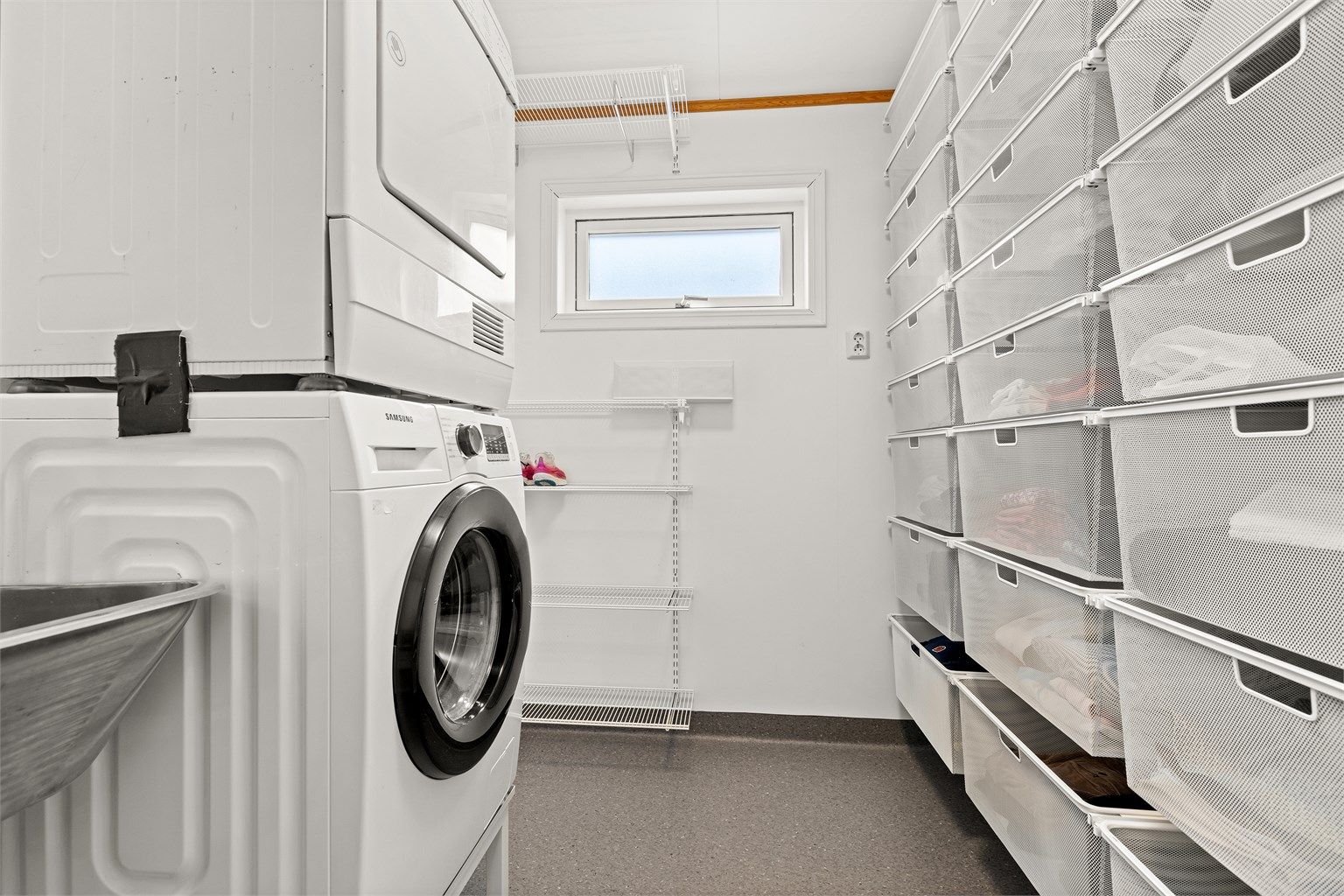 Innenfor badet i 1 etg ligger vaskerommet med praktisk innredning til tøy og vask