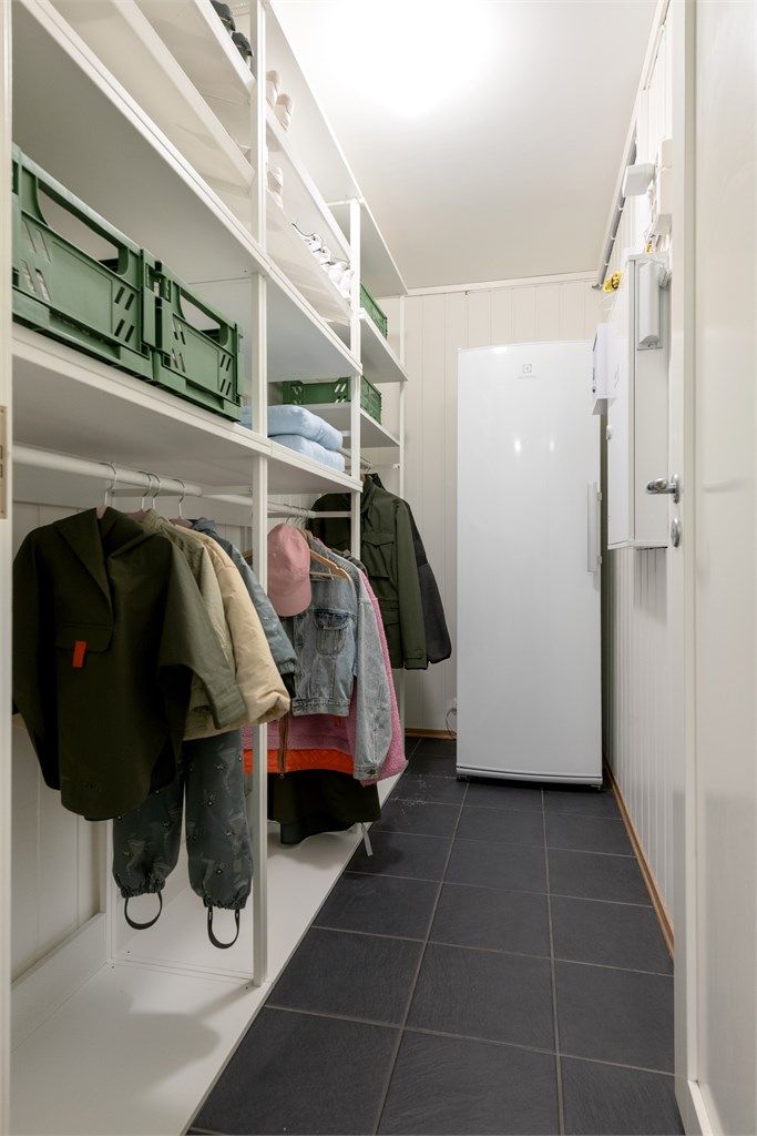 Innenfor vaskerommet er det en romslig bod med ny garderobeløsning som gir rikelig med lagringsplass.