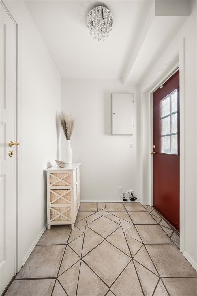 Entréen har flislagt gulv med varmekabler. De profilerte innerdørene i etasjen er fra 2024.