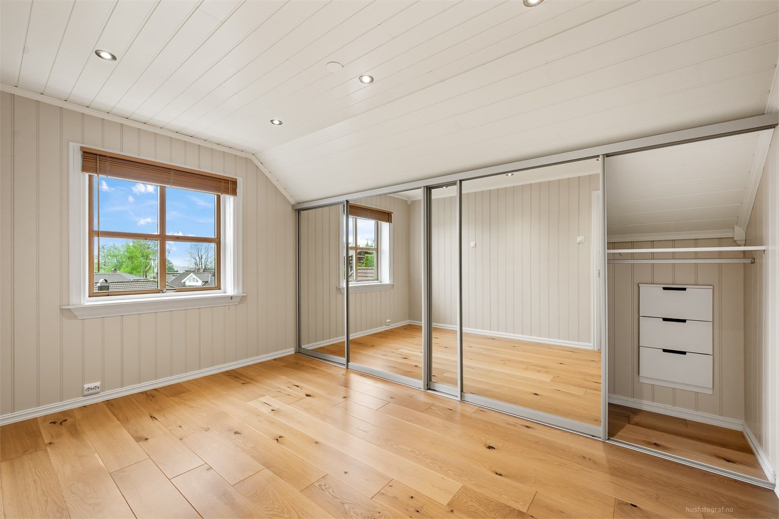 Romslig soverom med god plass og en stor skyvedørsgarderobe for effektiv oppbevaring.