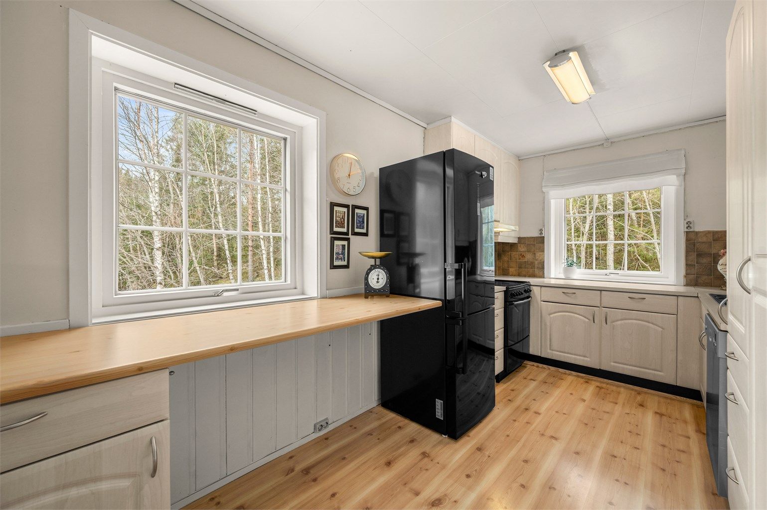 Ekstra benkeplass ved vinduet gir kjøkkenet en luftig følelse og gjør det enkelt å kombinere matlaging med oppbevaring og arbeidsflate.