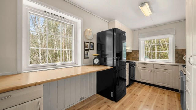 Ekstra benkeplass ved vinduet gir kjøkkenet en luftig følelse og gjør det enkelt å kombinere matlaging med oppbevaring og arbeidsflate.