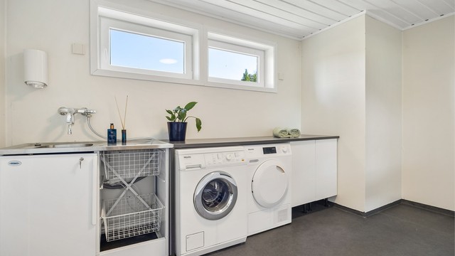 Separat vaskerom med skapinnredning og utslagsvask, rommet ble overflateoppusset i 2019.
