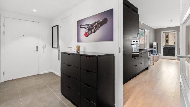 Romslig gang med flislagt gulv, gulvvarme og downlights