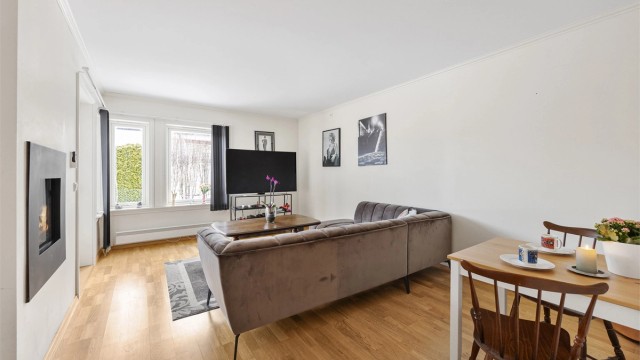Rommet er lett å møblere med plass til både sofagruppe og spisebord.