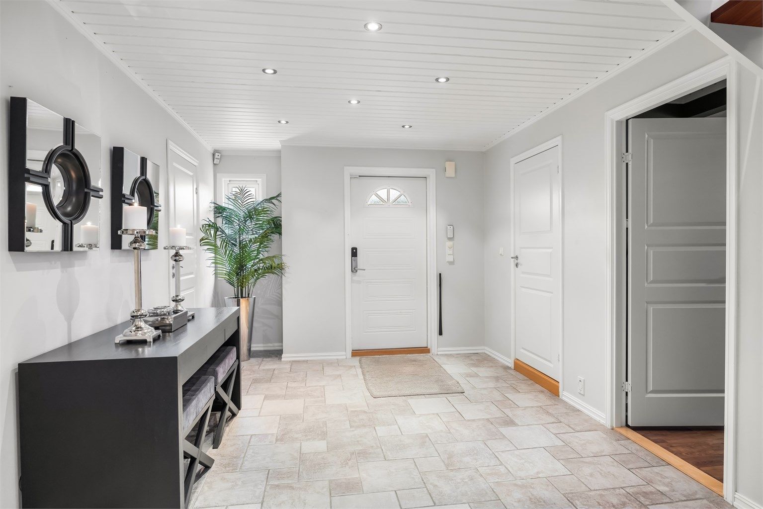 Fra det overbygde inngangspartiet kommer du inn i en romslig hall med flislagt gulv og varme.