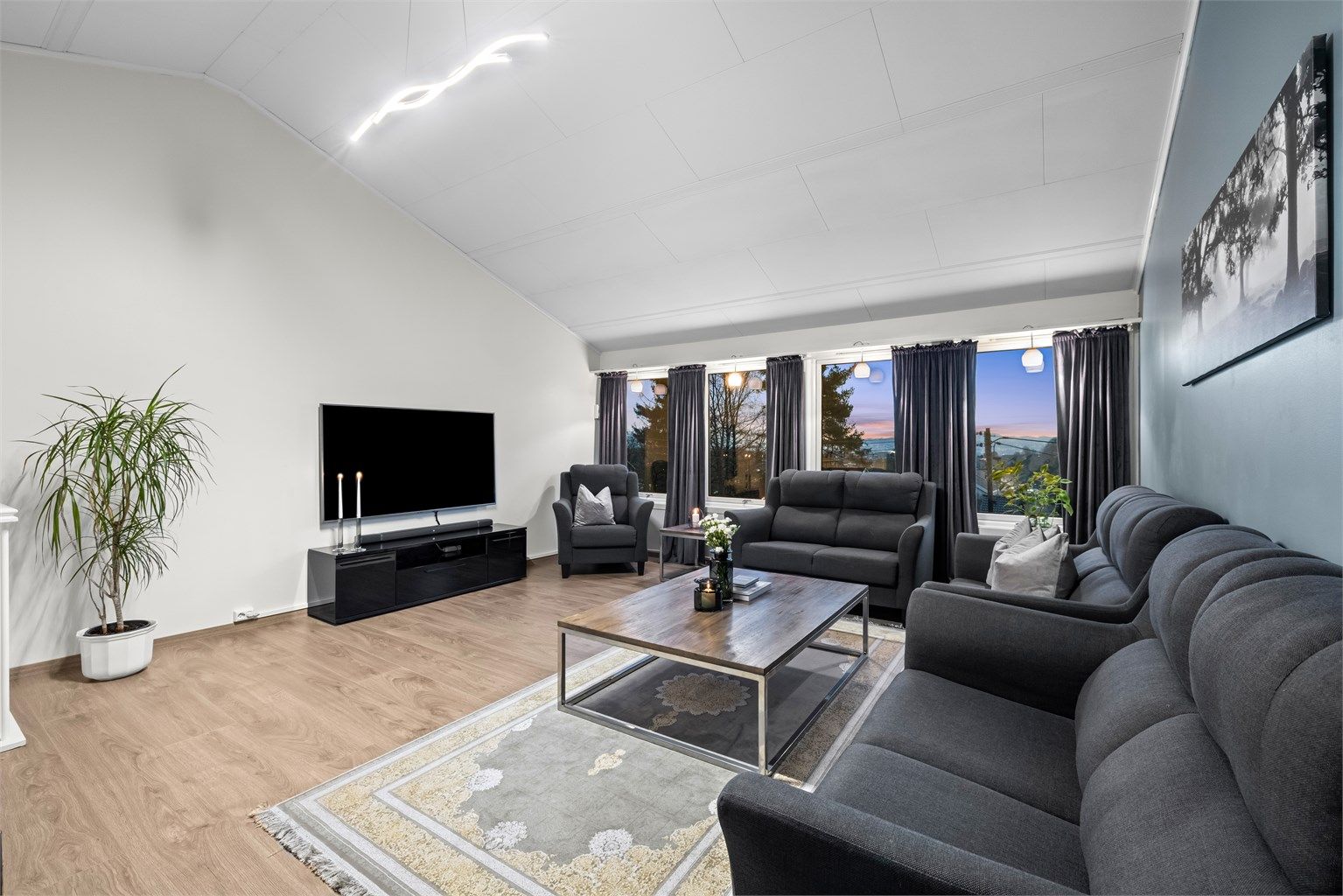 Stuen i øverste plan er et lyst og romslig samlingspunkt med god plass til flere sittegrupper.