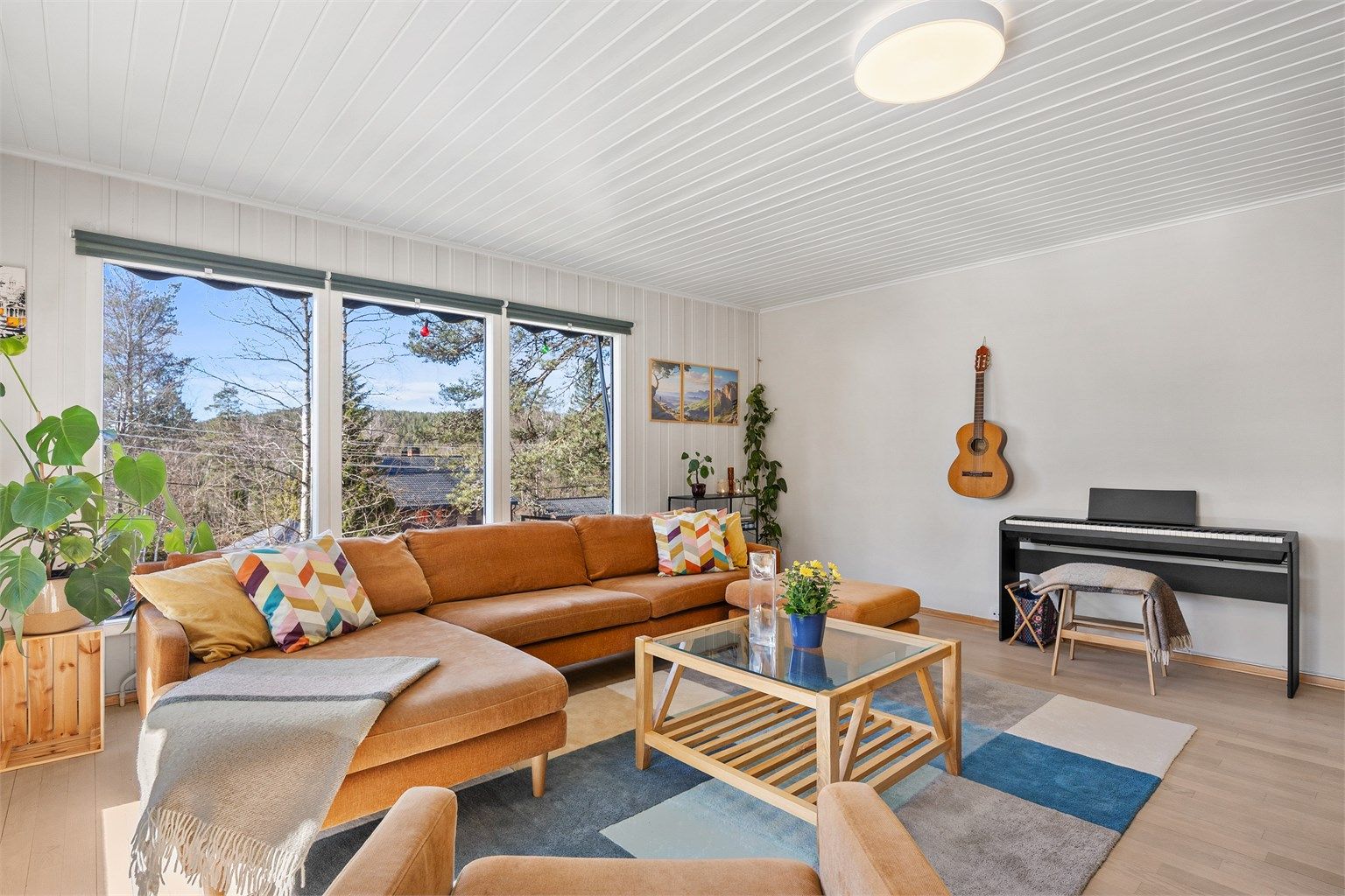 Romslig stue malt i lyse farger.