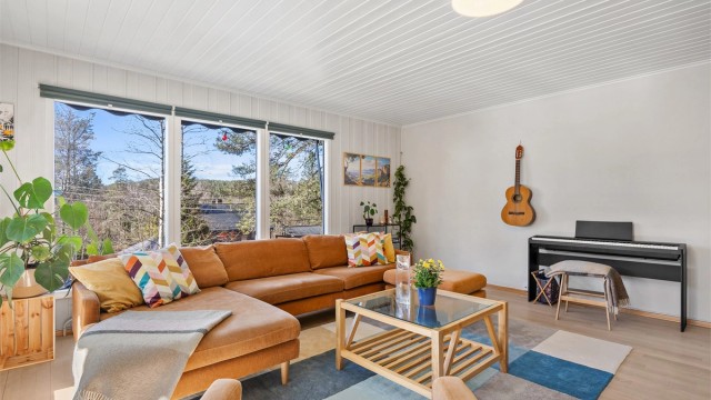 Romslig stue malt i lyse farger.