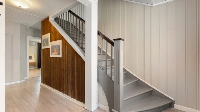 Den originale tretrappen binder etasjene sammen og bevarer boligens historiske sjarm.